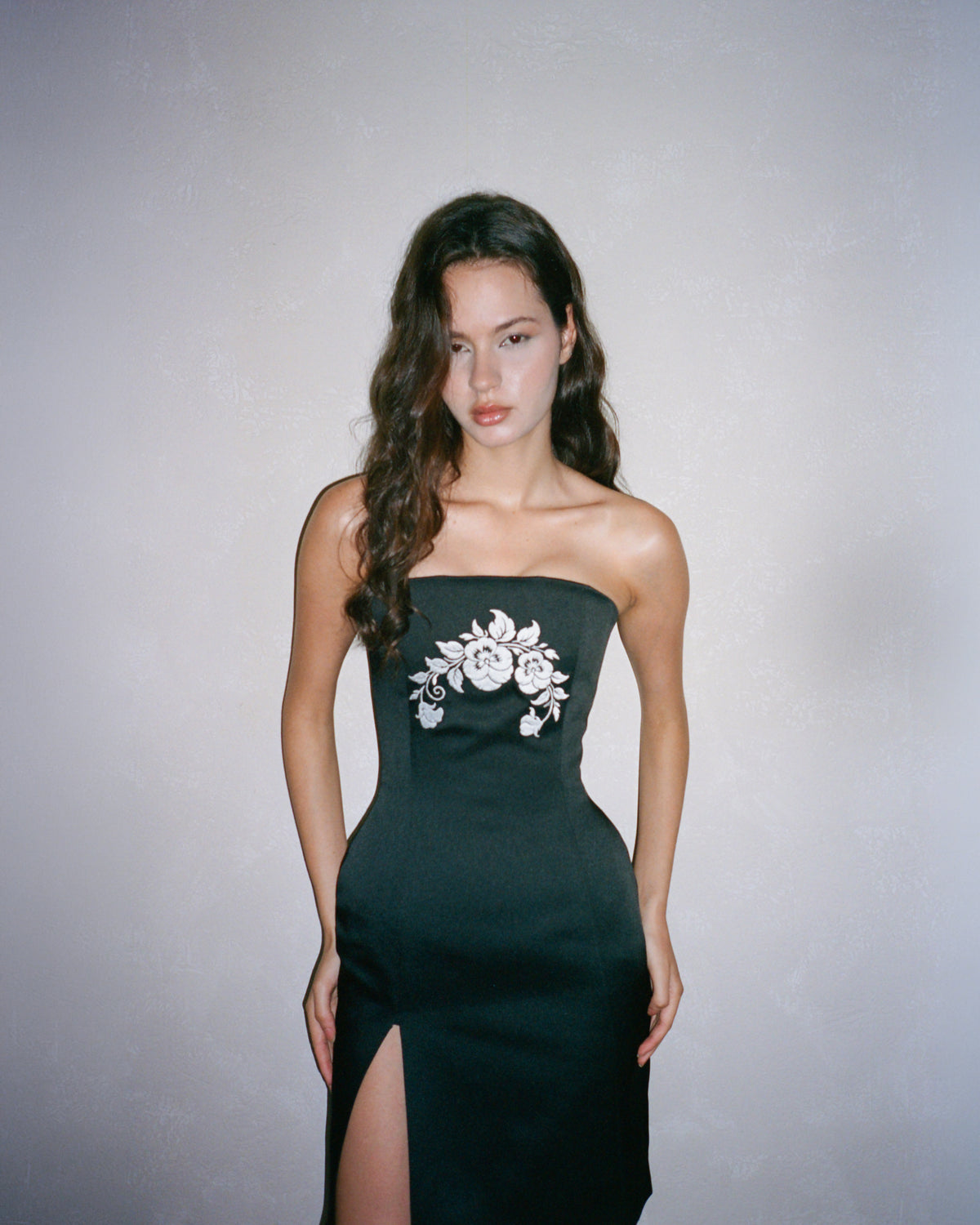 The Odile Dress from the front, cropped below the knee — the strapless bodice and the way the satin falls clean over the hip.